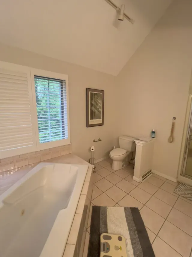 Master bathroom before the remodel with a built-in tub and older tile