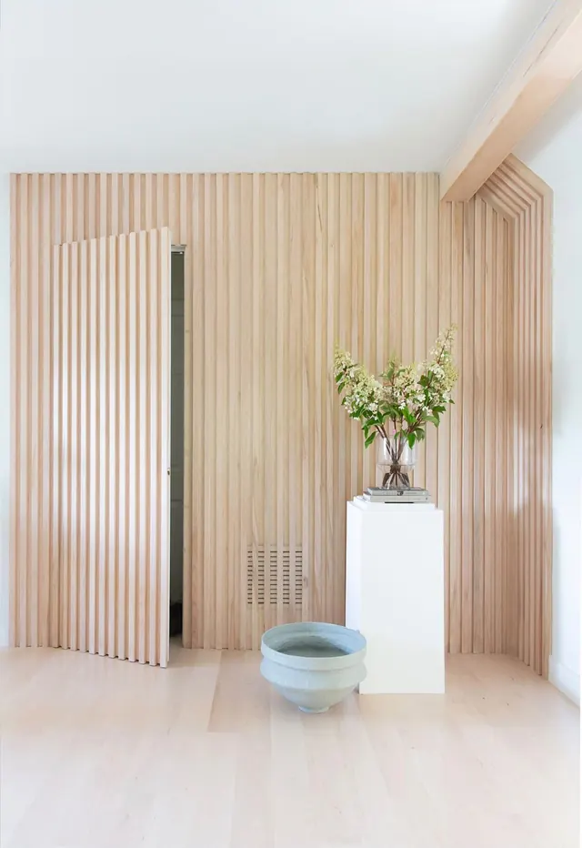 Maple slat wall with a hidden door, white oak beam and light maple floor