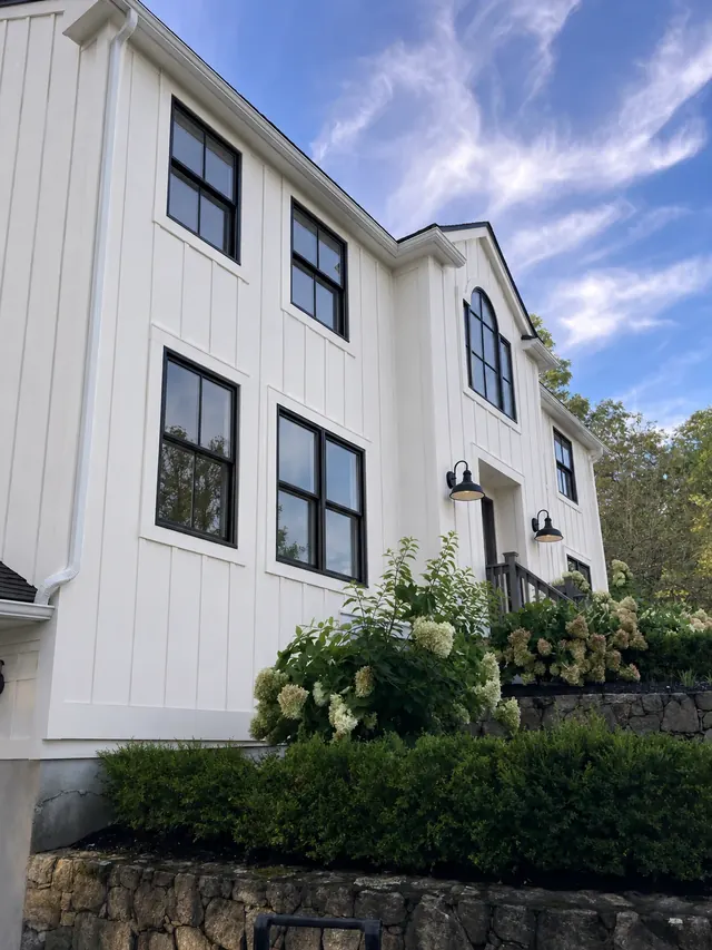House exterior after a siding replacement with white board and batten siding
