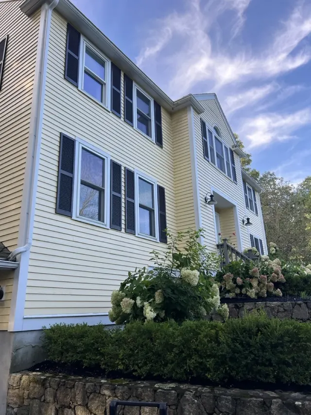 House exterior before the siding replacement with yellow clapboard siding