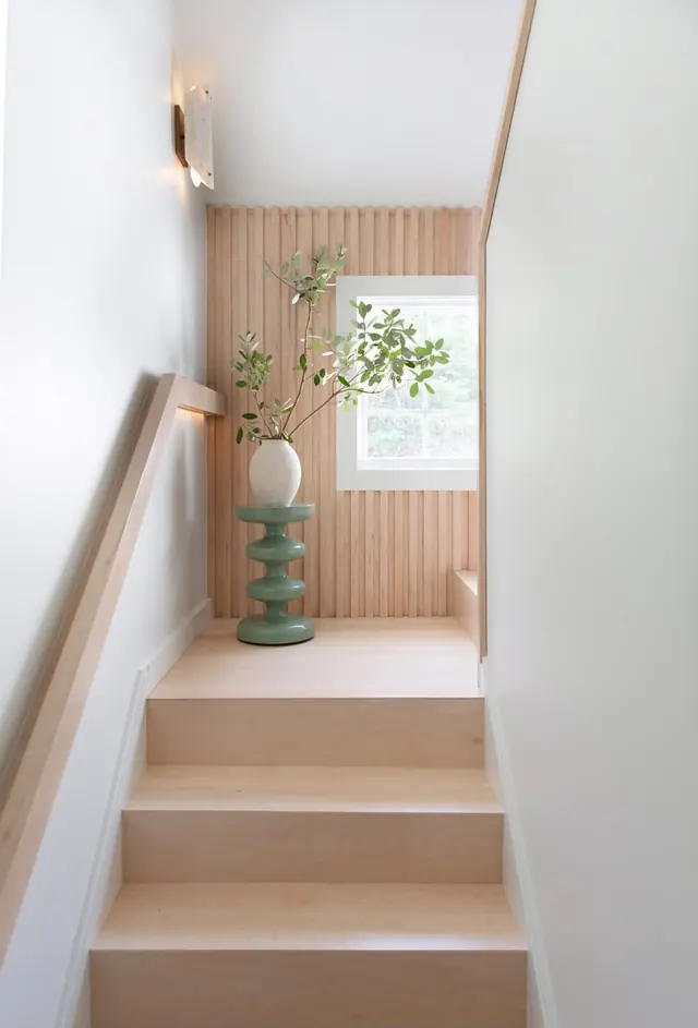 Staircase with maple treads, a wood handrail and a slatted maple accent wall