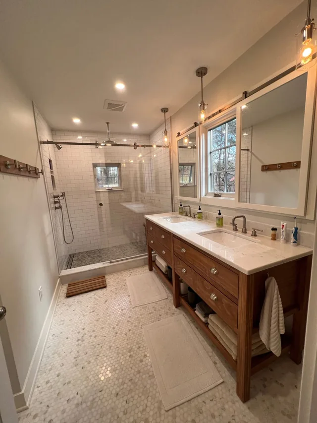 Master bathroom remodel with a double wood vanity and walk-in glass shower