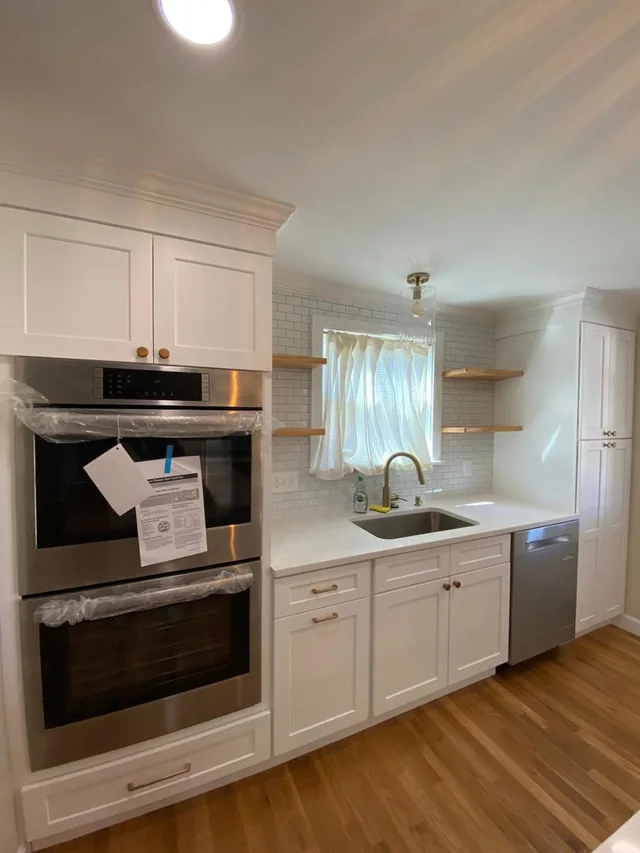 Kitchen remodel with white shaker cabinets, double wall oven and hardwood floors