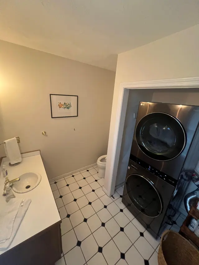 Laundry area in Marlborough before the remodel, with the stacked washer and dryer next to the toilet