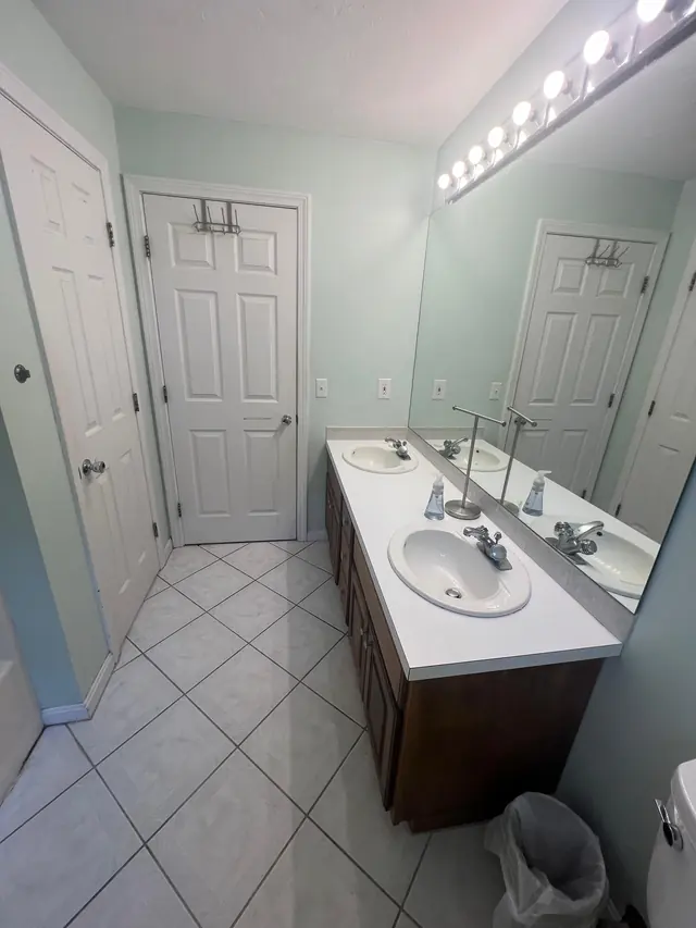 Main bathroom in Marlborough, MA before the remodel, with a long vanity and tile floor