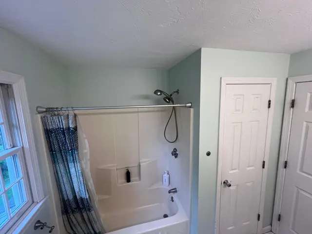 The original tub and shower with a curtain in the Marlborough main bathroom