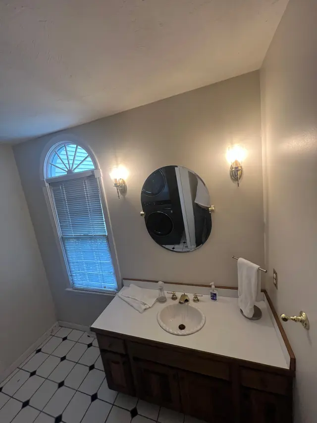 Powder room in Marlborough, MA before the remodel, with a basic vanity and checkered tile